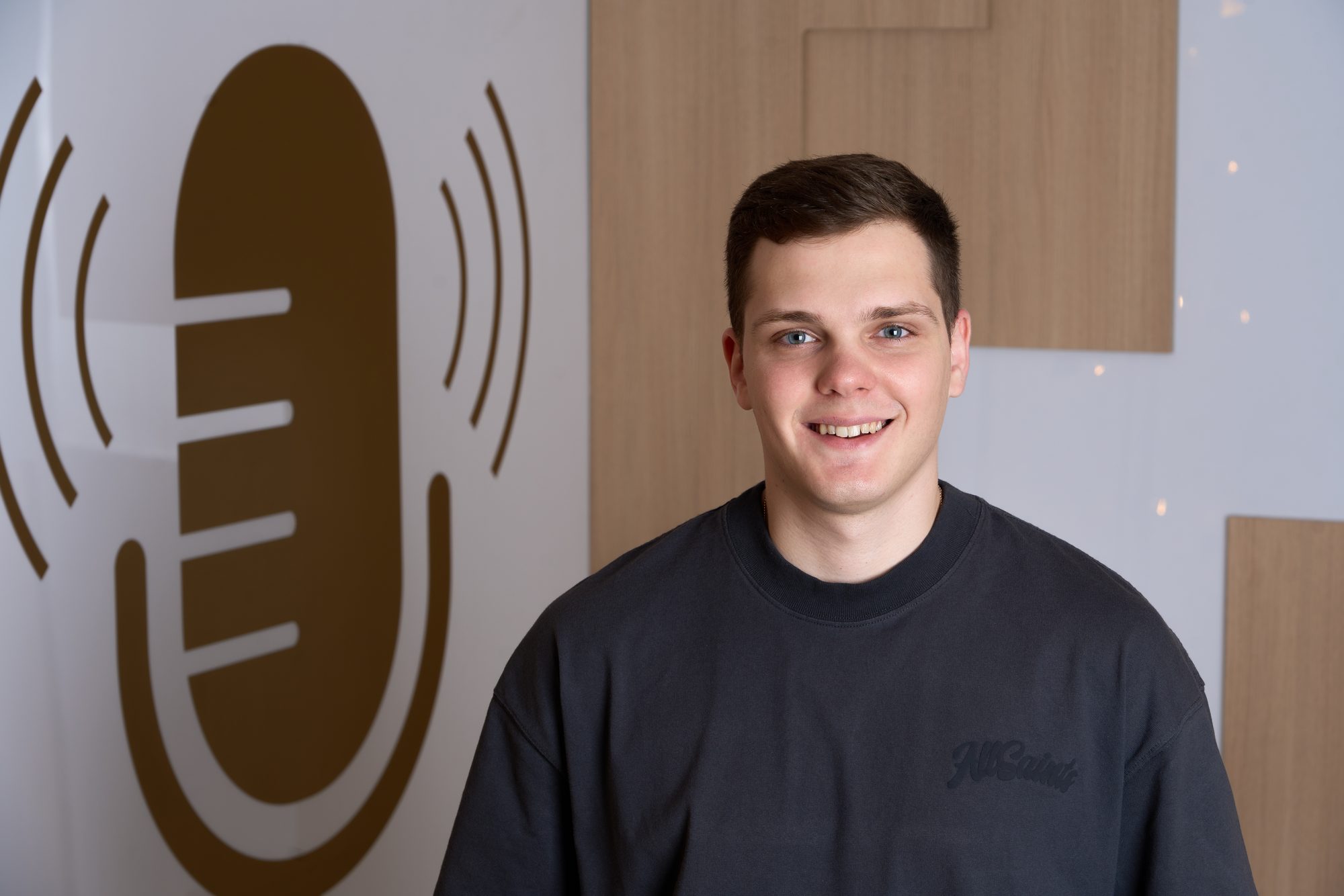 Maximus in front of the studio microphone wall