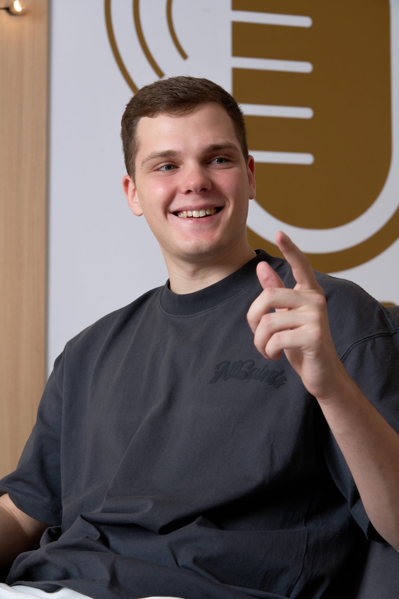 Maximus smiling and pointing to the side in the One-on-One studio